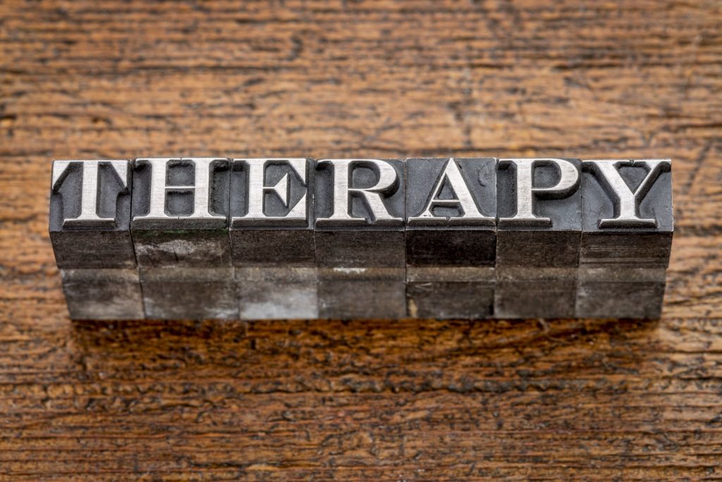 therapy word in mixed vintage metal type printing blocks over grunge wood